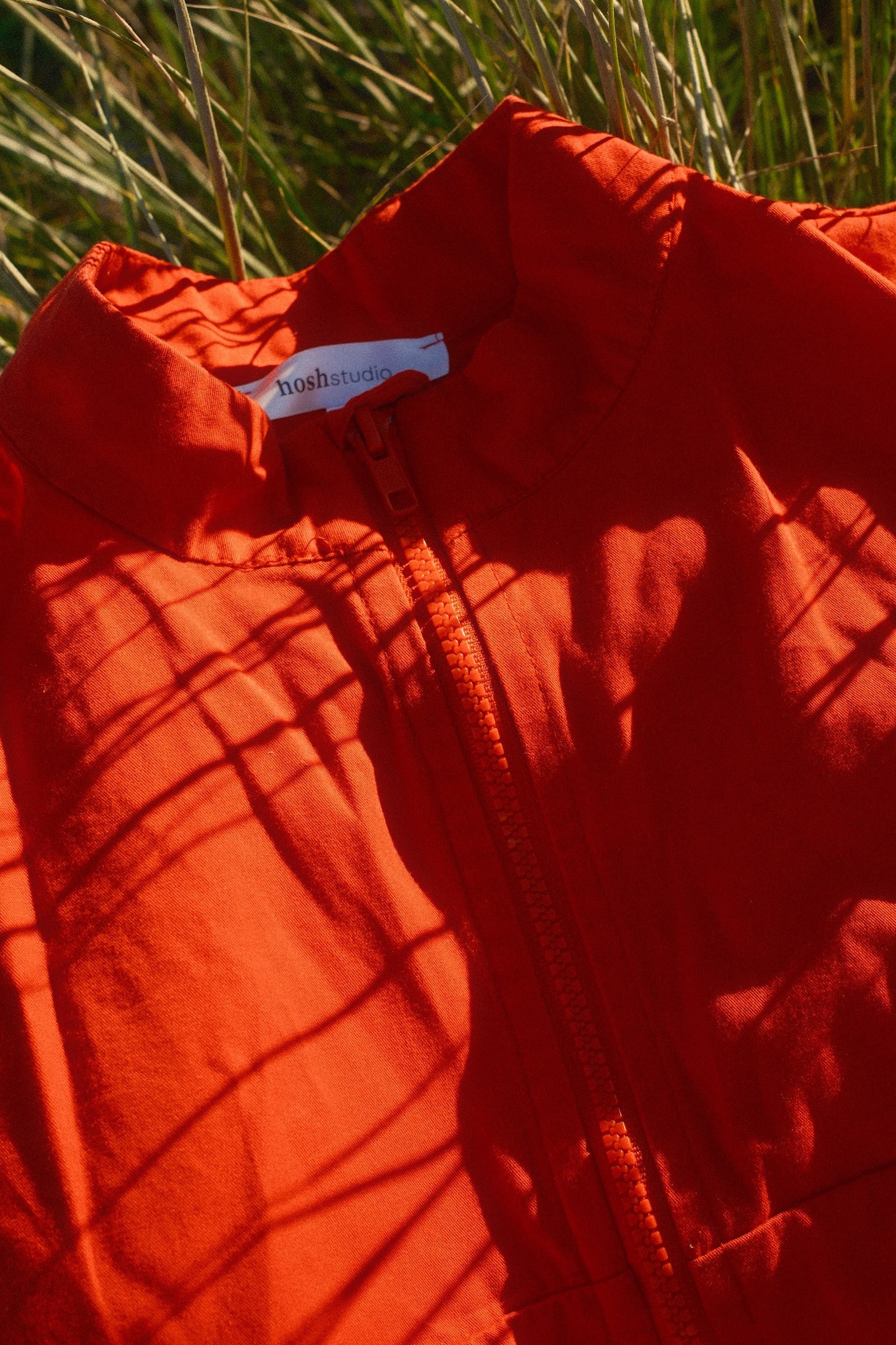 Red jacket with a tag on grass