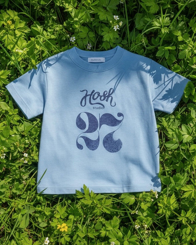 Blue t-shirt with a design on grass
