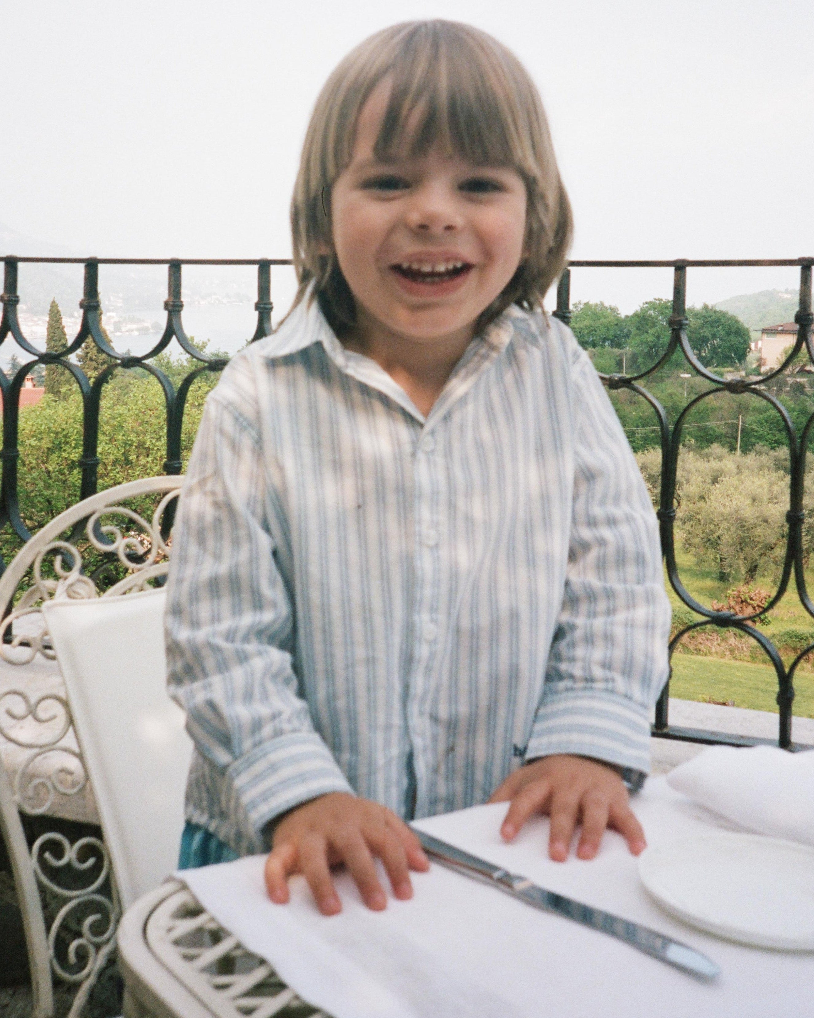 Child sitting at a table with a scenic background