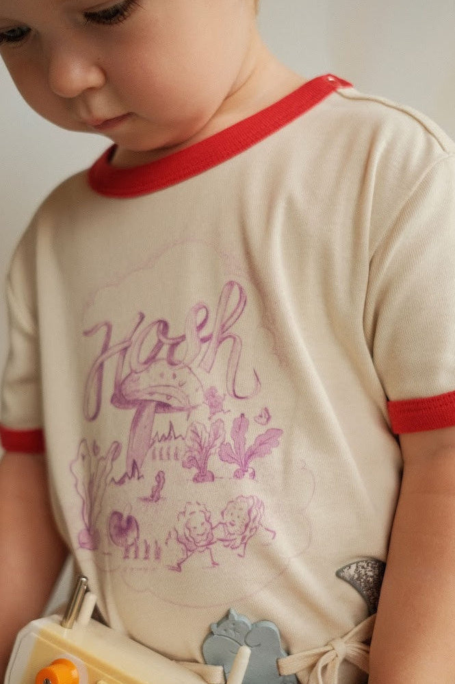 Child playing with a vintage toy machine against a plain background