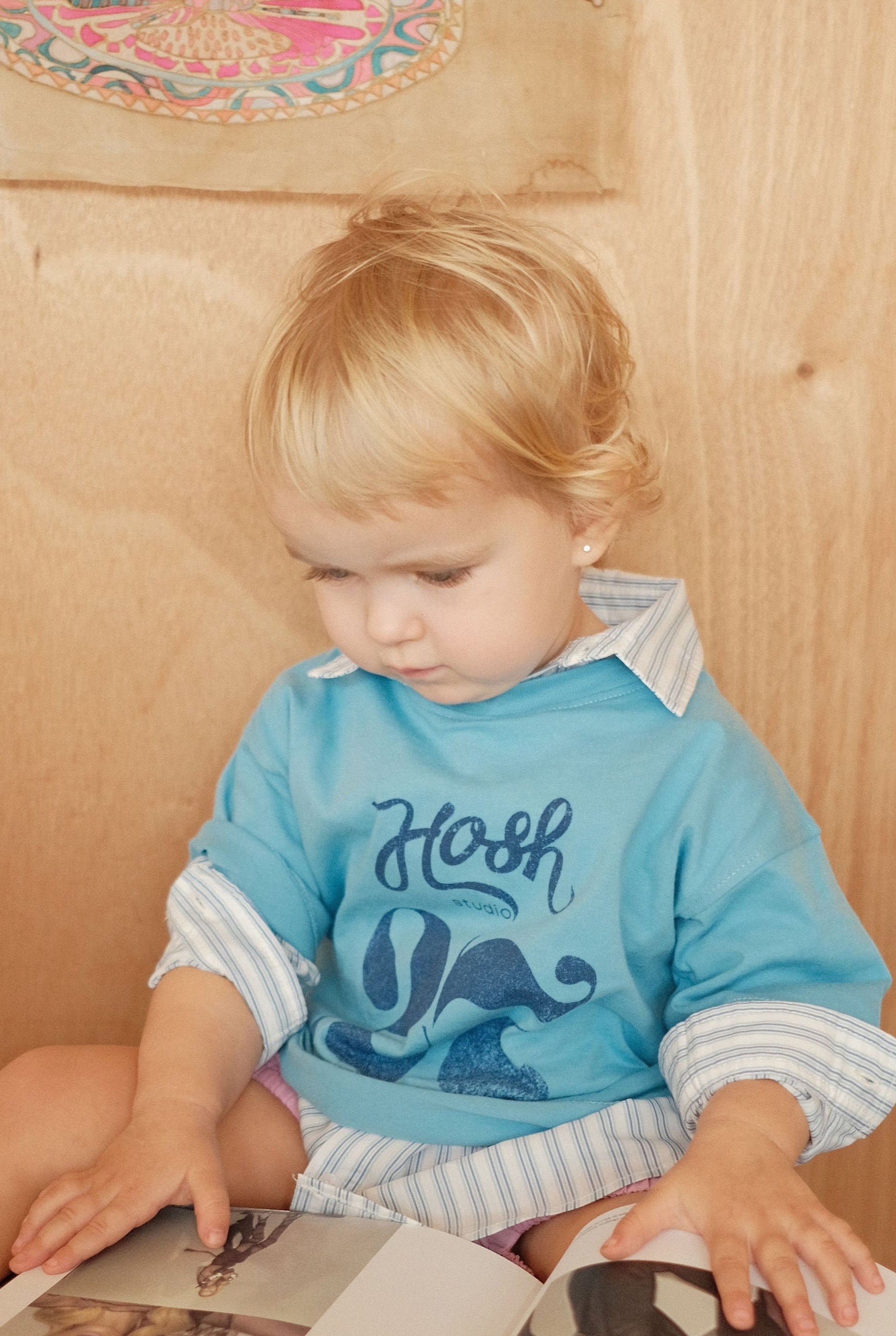 Child reading a book with butterfly illustrations in a cozy room.