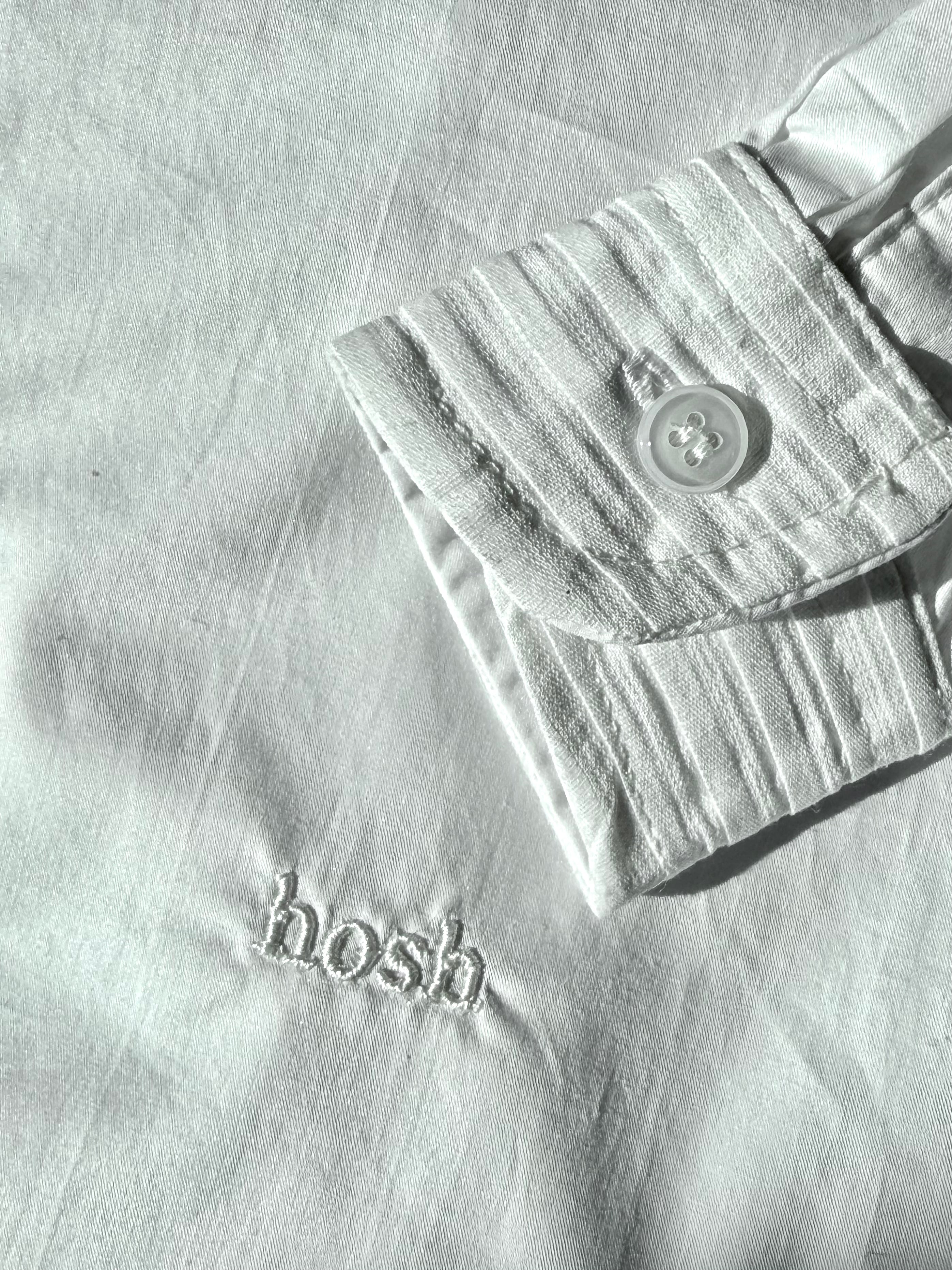 Light white shirt with 'hosh' branding on a matching fabric background