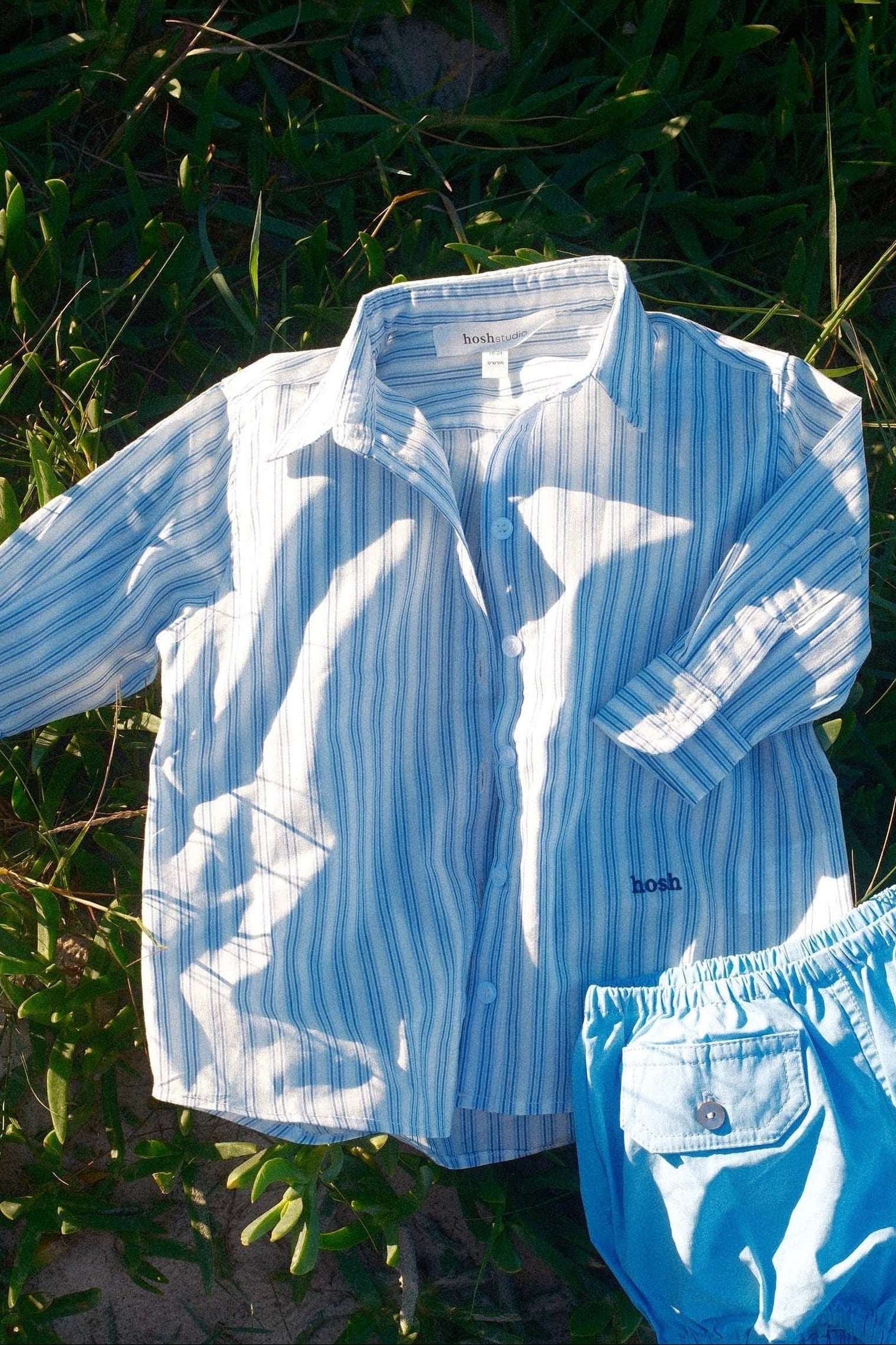 Blue striped shirt and diaper on grass