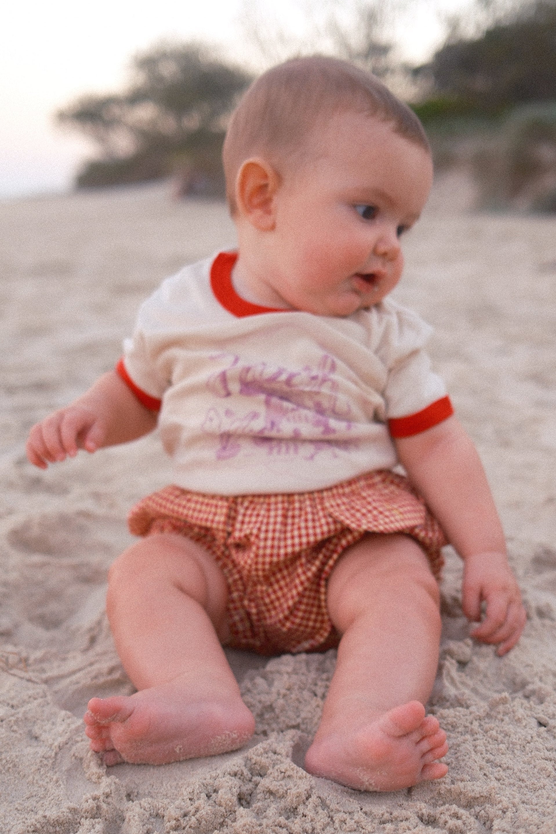 Baby lying on a stone surface with a blurred natural background