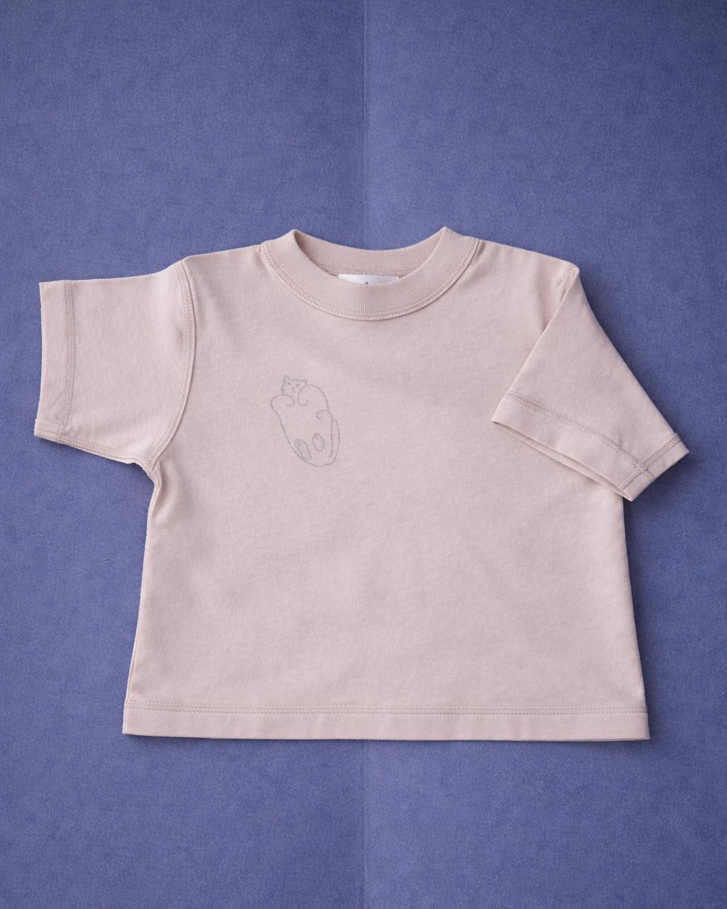 Beige t-shirt with a small design on a purple background